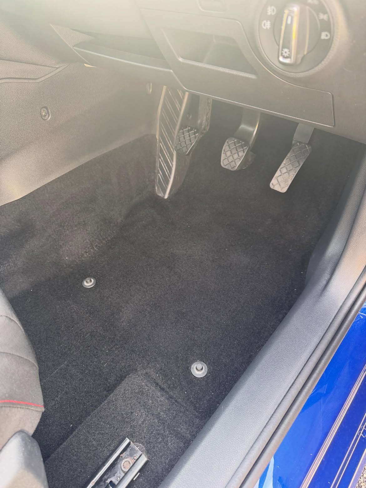 The same driver's footwell after a deep clean, carpet uniform and dark