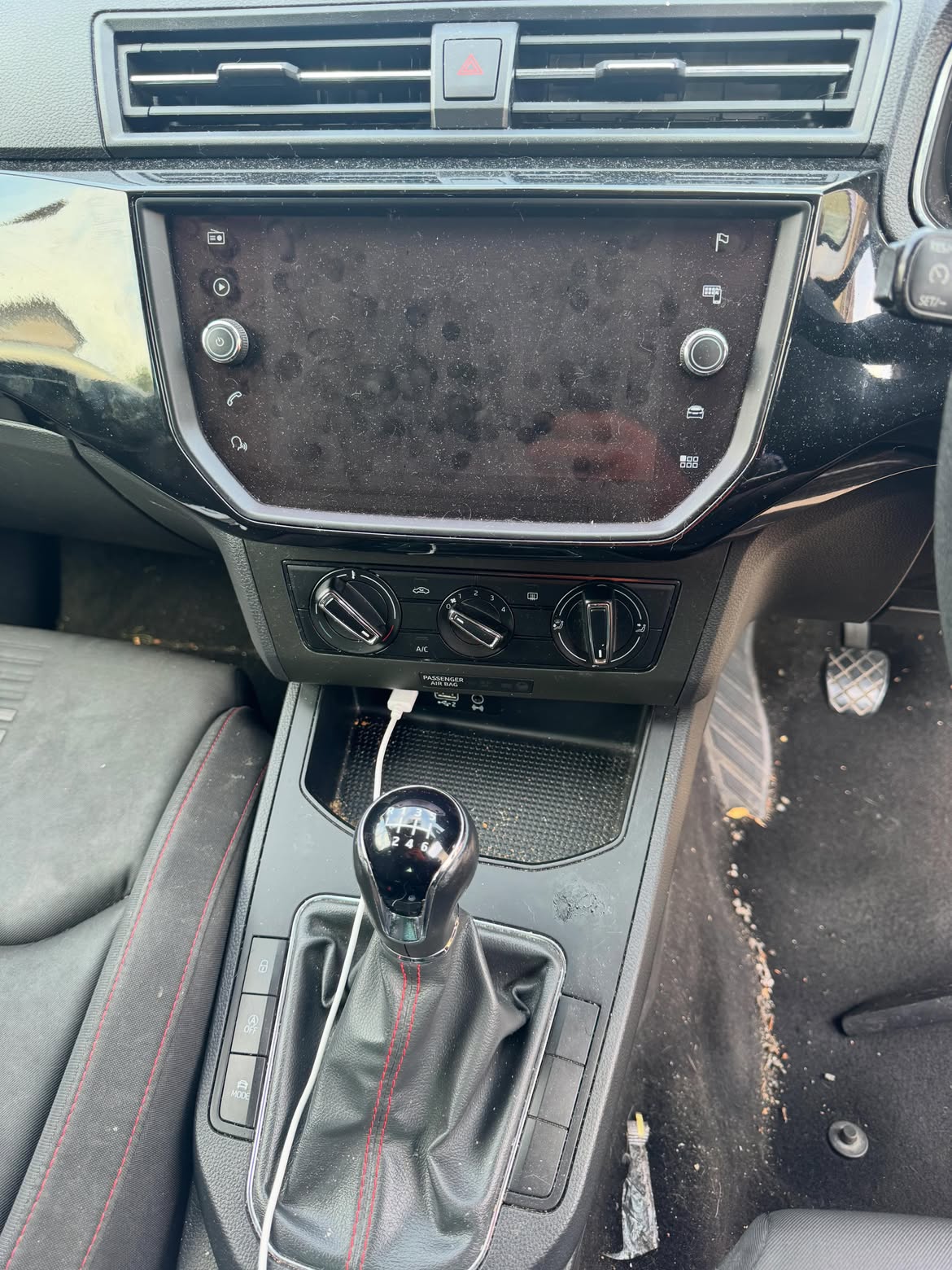 Dashboard and infotainment screen before cleaning, dust and fingerprints throughout