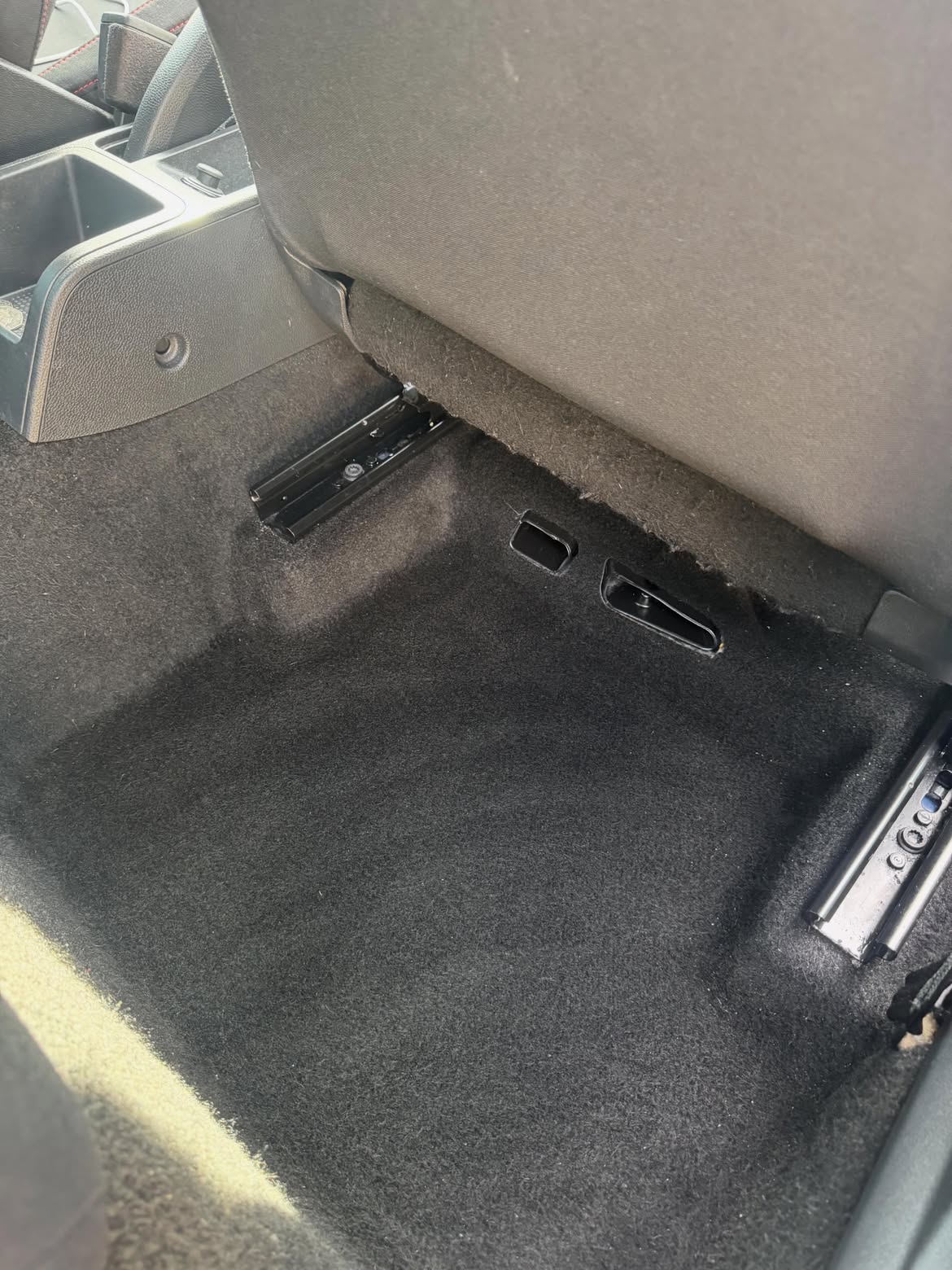 The same rear footwell after cleaning, carpet and seat rails clear